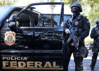 Operação da Polícia Federal com agentes armados em veículo oficial.