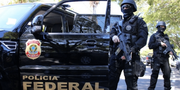 Operação da Polícia Federal com agentes armados em veículo oficial.