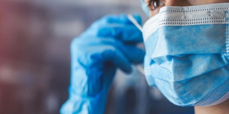 Profissional de saúde com máscara e luvas representa os médicos formados no exterior que aguardam o resultado da primeira etapa do Revalida 2026/1