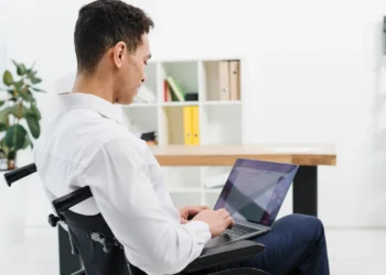 Estudante com deficiência utilizando notebook representa participantes do Enade 2026 que podem acessar o resultado de recurso sobre atendimento especializado.