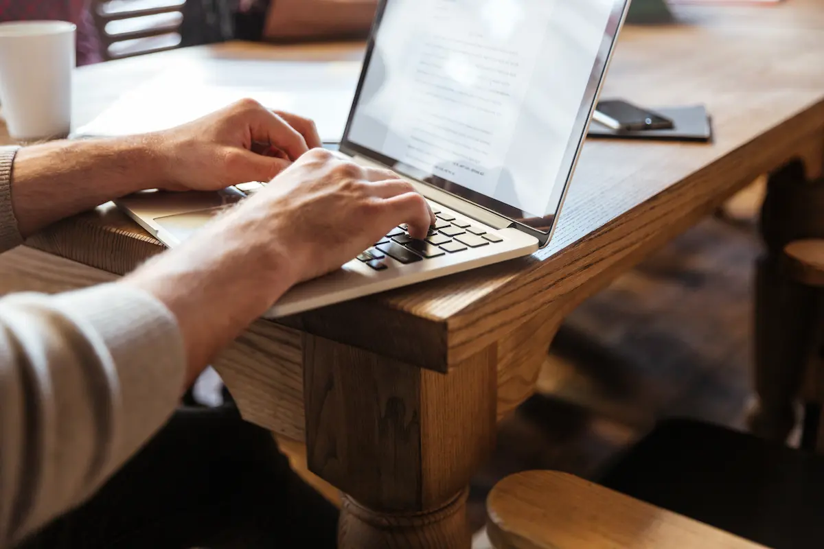Pessoa utilizando notebook para acessar informações sobre o recurso de atendimento especializado do Enade 2026.