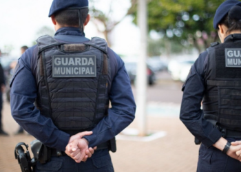 Guardas Municipais em patrulhamento urbano nas ruas de cidade brasileira.
