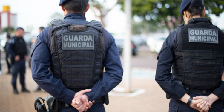 Guardas Municipais em patrulhamento urbano nas ruas de cidade brasileira.