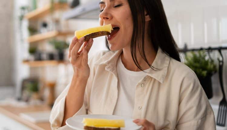 Muçarela ou mussarela Mulher com cabelos soltos comendo fatia de queijo