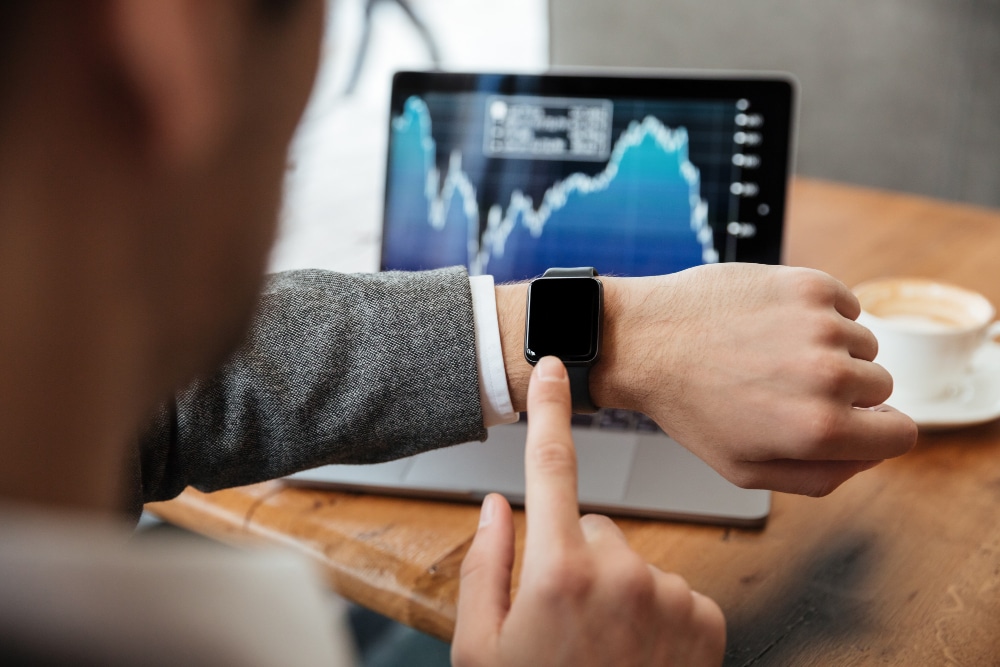 Executivo no trabalho olhado seu relógio digital