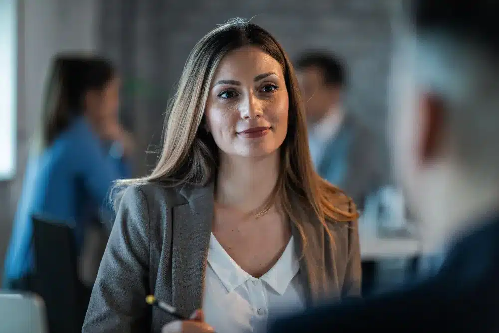 Profissional enfrentando desafios com autoconfiança e mentalidade de crescimento Mulher com expressão confiante em ambiente de trabalho, simbolizando uma mentalidade de crescimento