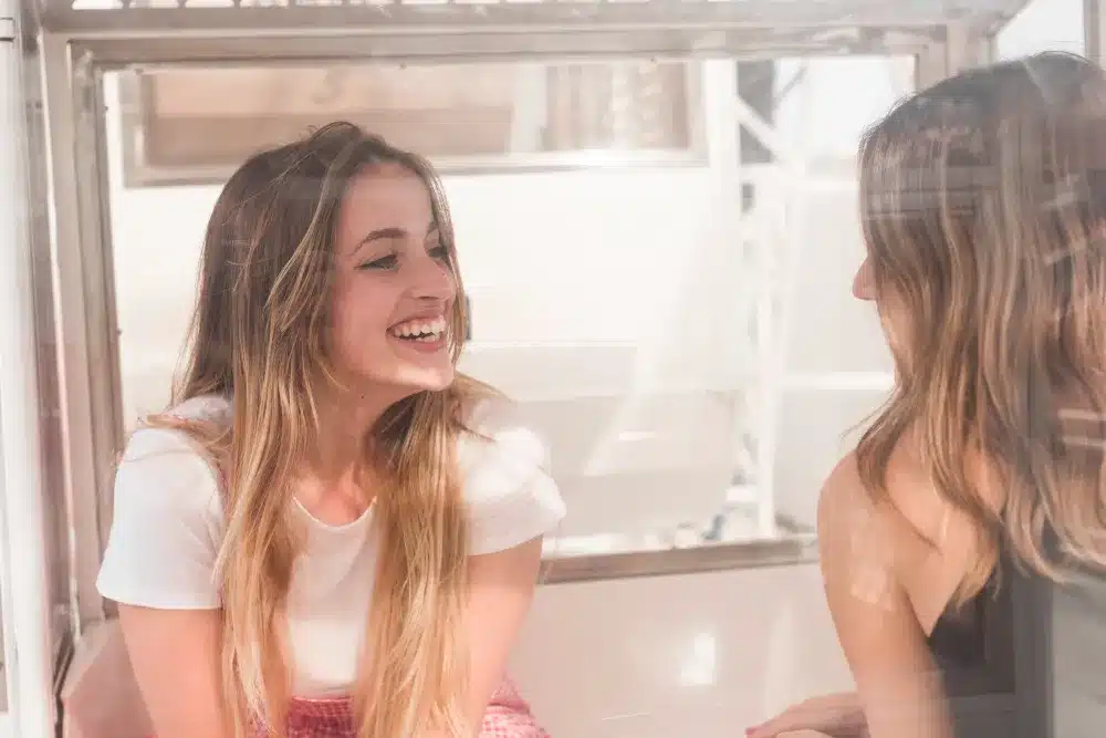Duas pessoas sorrindo e conversando, representando a felicidade e a conexão