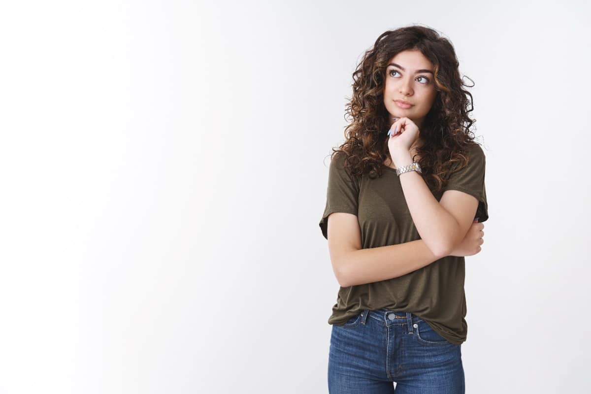 Mulher pensativa olhando para o lado, representando dúvida sobre o coletivo de borboleta.