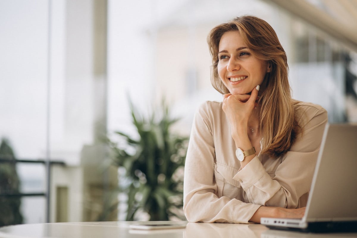 Mulher sorridente simbolizando confiança e realização profissional.