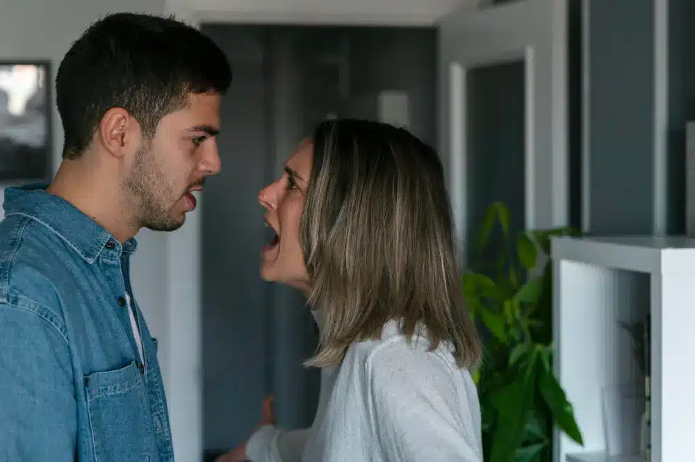 Atribuir culpa ao parceiro pode destruir o relacionamento. Casal discutindo de forma intensa, com expressões de raiva e frustração.