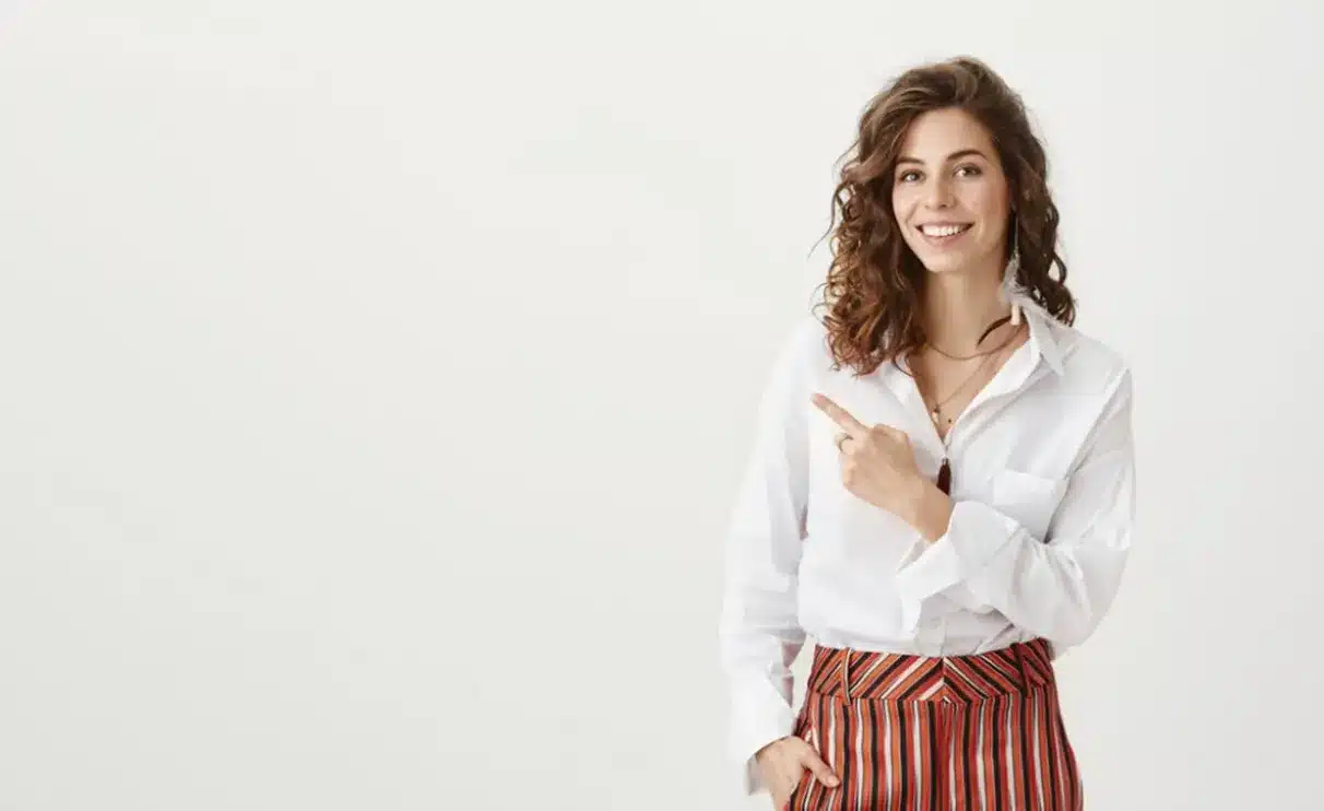 Deixando o passado para trás: um passo para a resiliência. Mulher sorridente apontando para o lado, simbolizando a atitude de deixar o passado para trás.