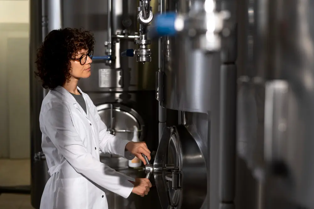 Engenheira Química em Ação no Laboratório Mulher em um laboratório de engenharia química, utilizando equipamentos industriais para monitoramento e controle de processos.