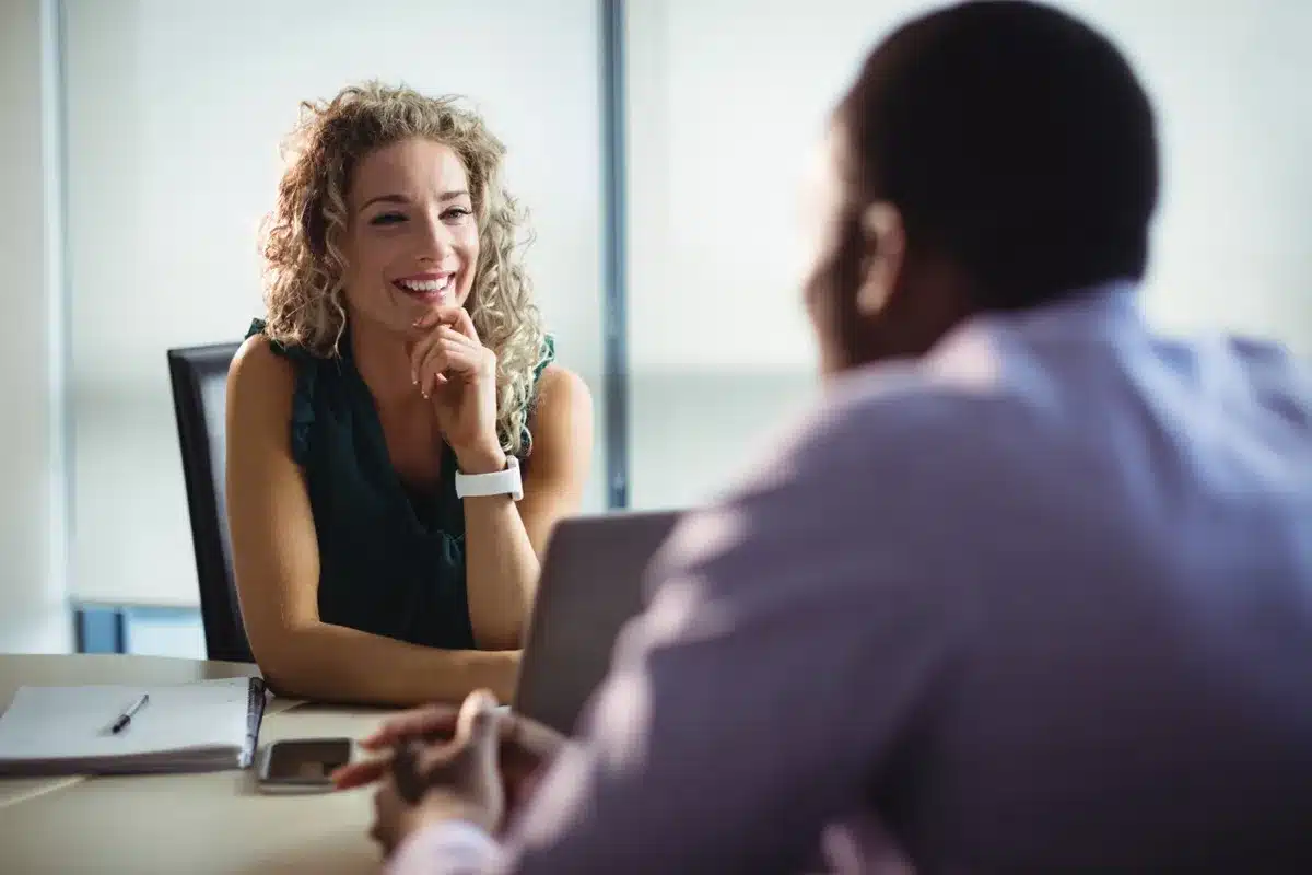 Mulher sorridente em conversa, representando expressões faciais e linguagem corporal analisadas pela psicologia.