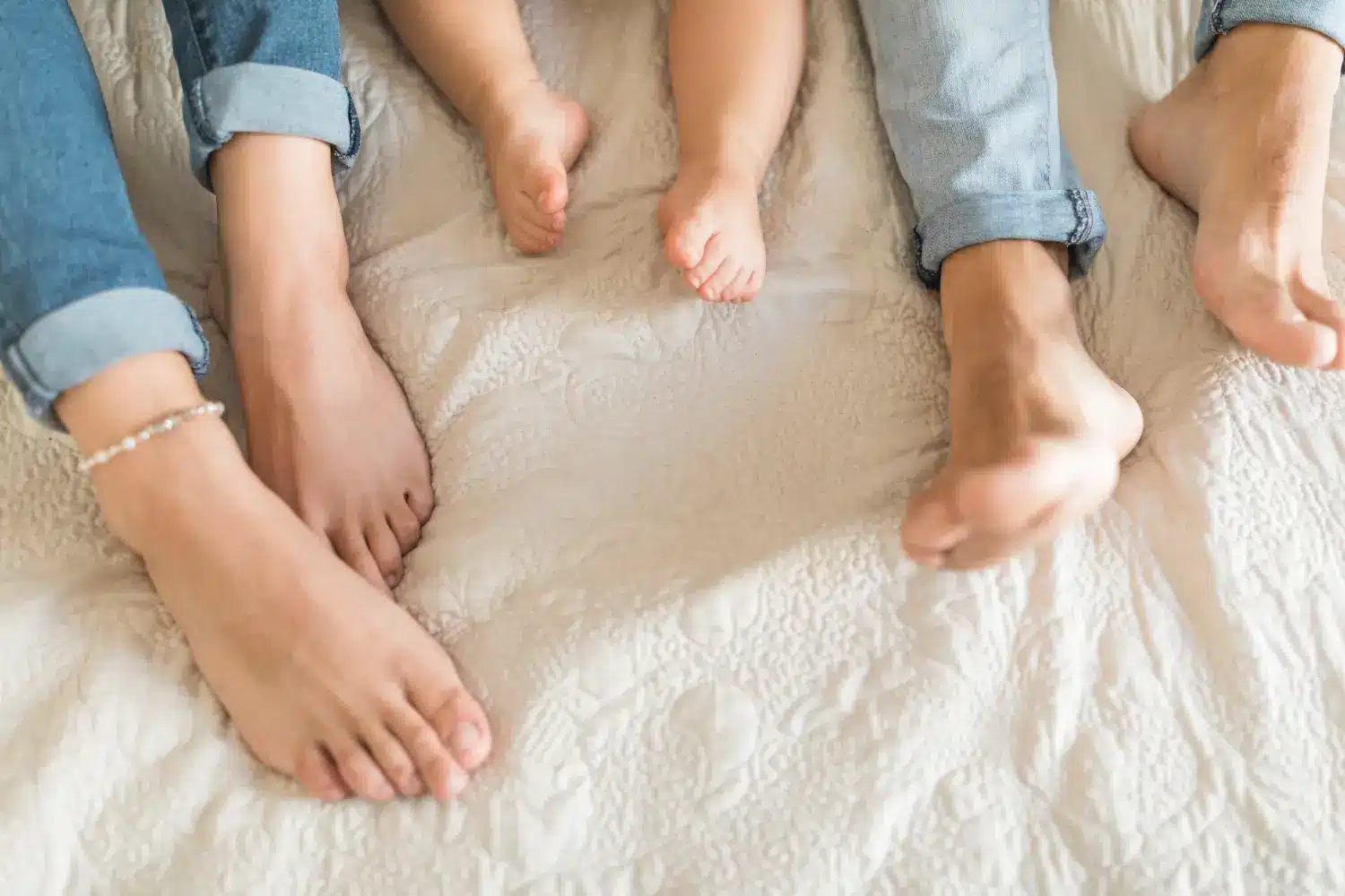 Foto de pés de uma criança e dois adultos, simbolizando a conexão familiar e a relação entre o formato dos pés e a personalidade