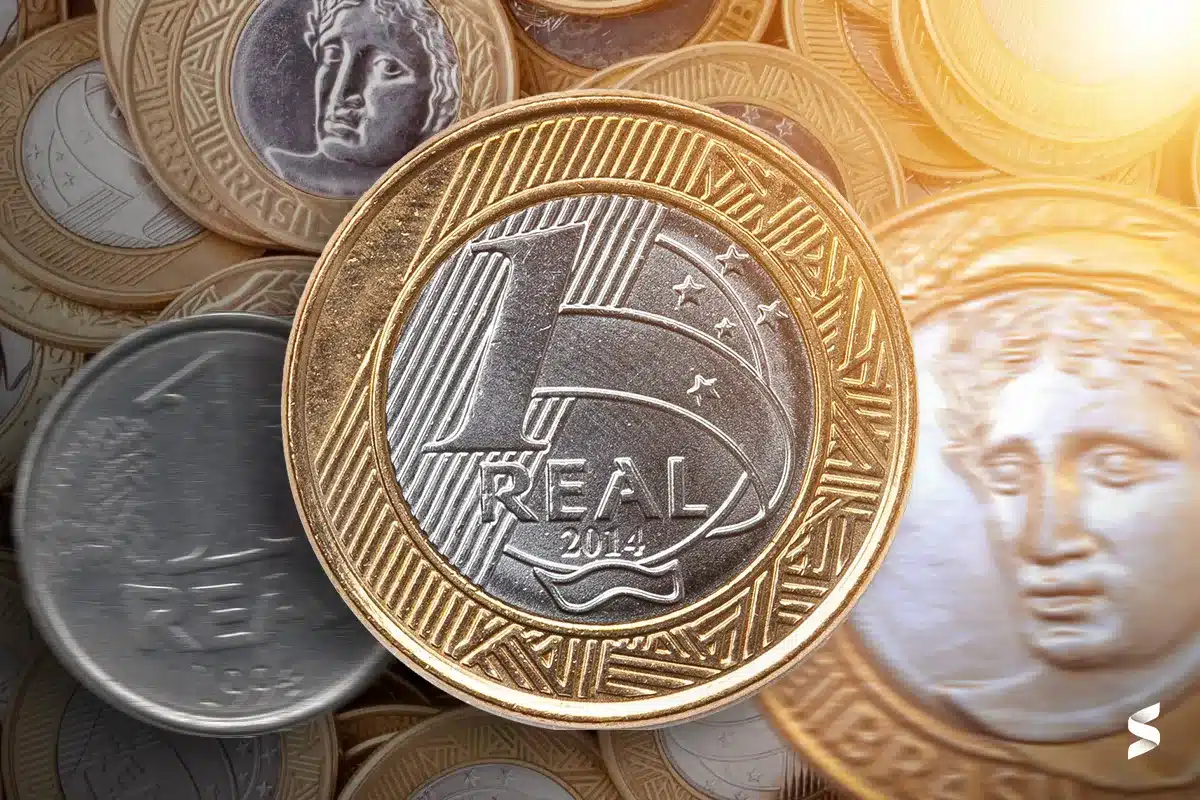 Moeda de 1 real destacada sobre outras moedas brasileiras