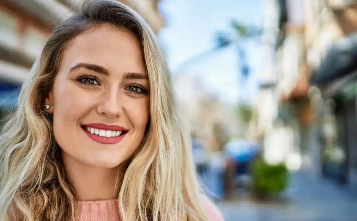 Mulher sorrindo ao ar livre, representando como o sorriso reflete traços de personalidade
