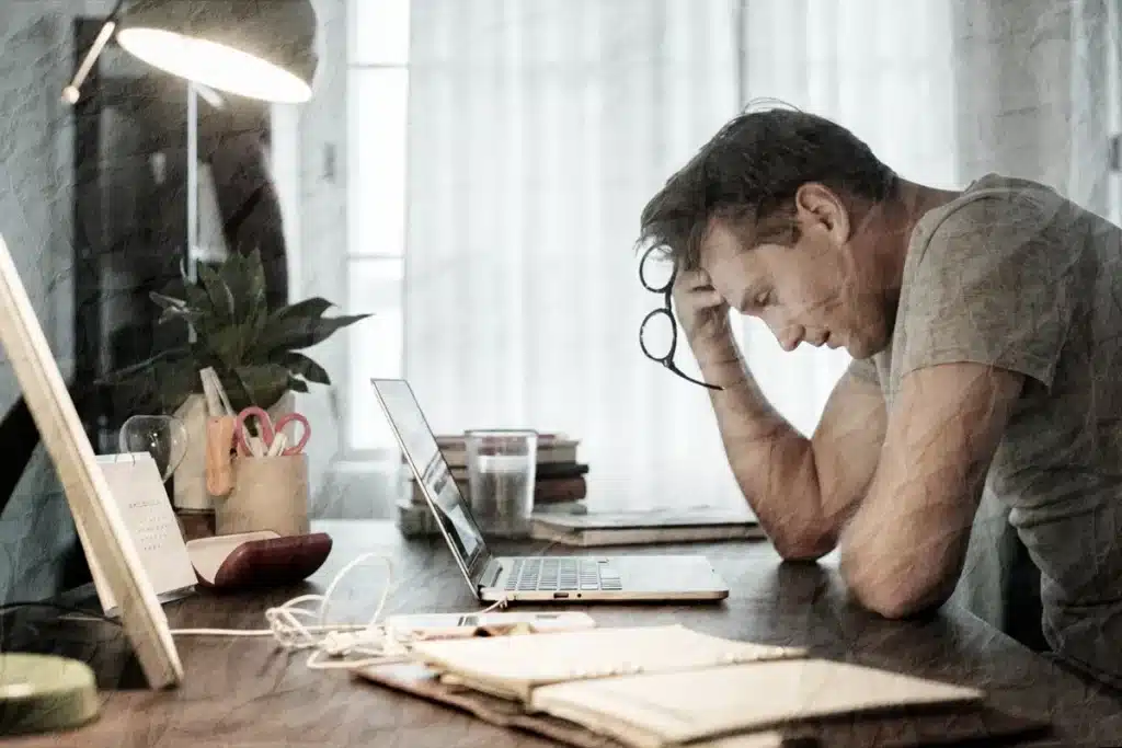 Propensão à preocupação e análise profunda Homem preocupado analisando informações no laptop, representando a propensão à preocupação e análise profunda.