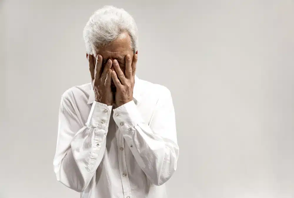 Homem idoso com expressão de sofrimento, simbolizando os desafios emocionais e cognitivos enfrentados por aqueles com demência