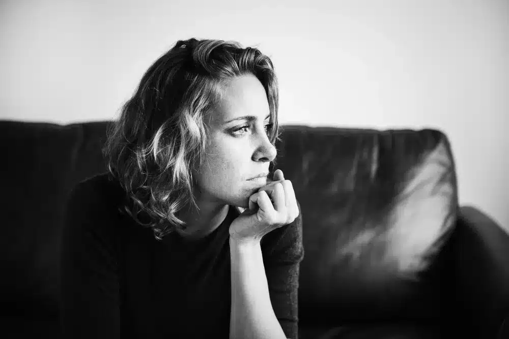 Mulher pensativa com expressão séria, refletindo sobre traços de personalidade.