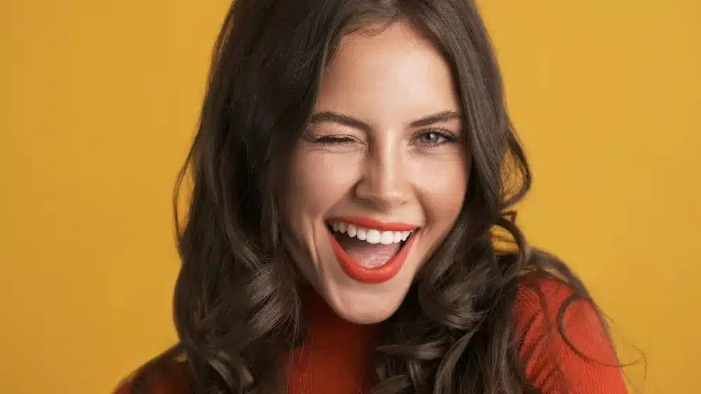 O poder do sorriso na comunicação não verbal. Mulher sorrindo e piscando, expressando alegria e confiança na comunicação.