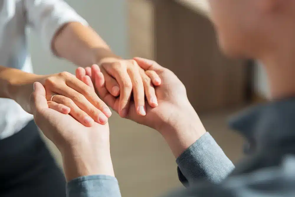 A Importância da Validação Emocional nas Relações Duas pessoas segurando as mãos, representando empatia e validação emocional.