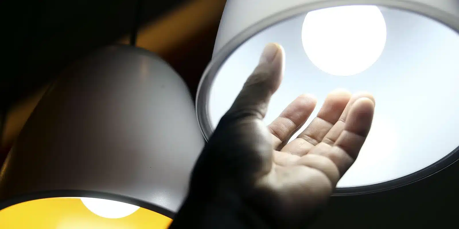 Dúvidas Frequentes sobre a Tarifa Social de Energia Elétrica. Pessoa ajustando a lâmpada LED para economia de energia.