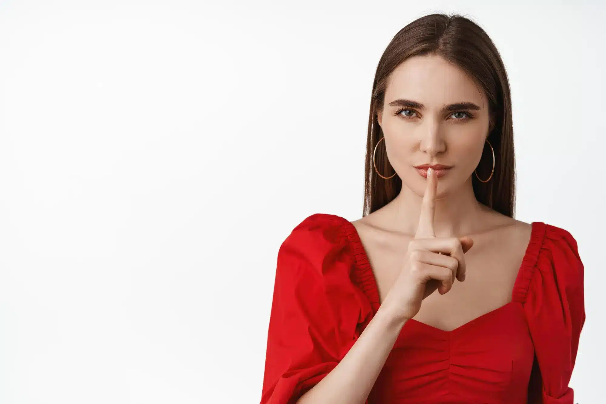 Mulher com vestido vermelho fazendo o gesto de silêncio, simbolizando o conceito de manter segredos segundo os filósofos estoicos.