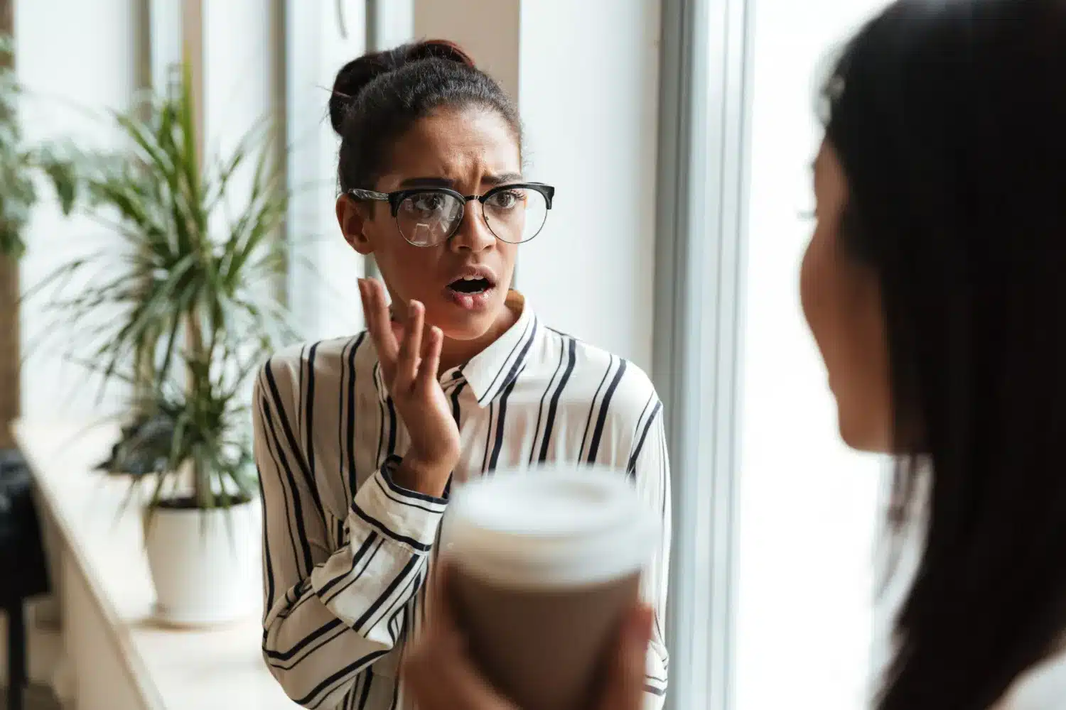 eações emocionais durante uma conversa sobre a verdade ou mentira. Mulher com expressão surpresa e preocupada ouvindo outra pessoa, simbolizando uma reação emocional em uma conversa.