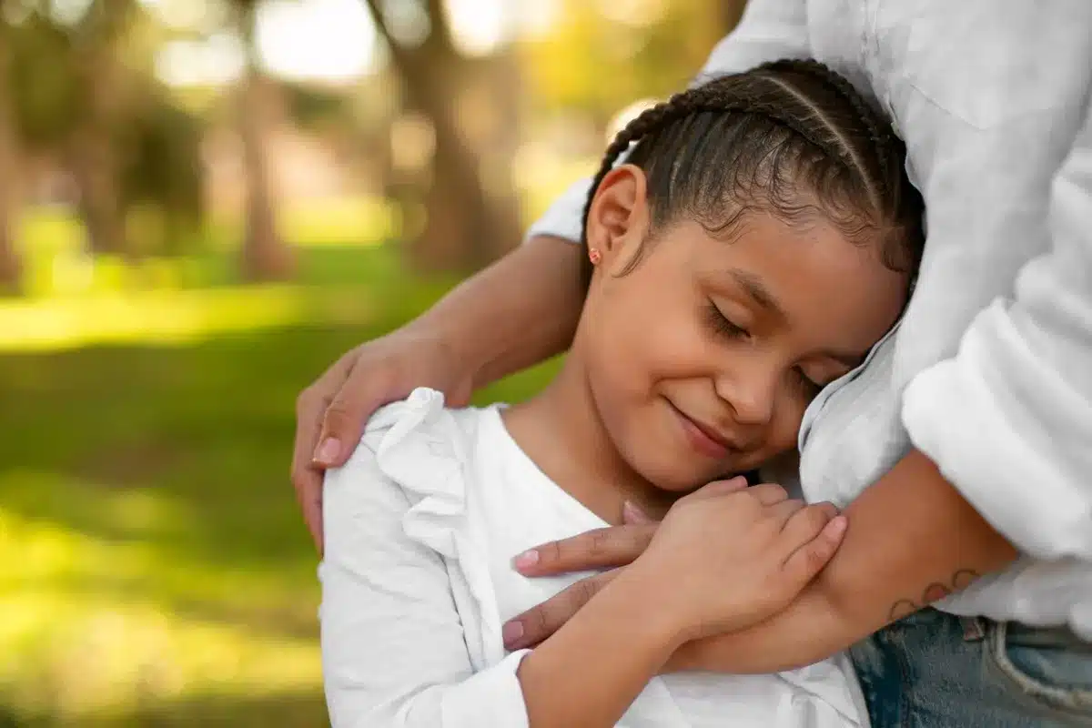 Imagem de uma mãe adotiva abraçando sua filha, simbolizando o vínculo afetivo e a questão do direito ao salário-maternidade no INSS para mães adotivas.
