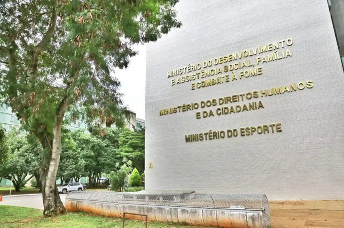 Imagem da fachada de um edifício público com o nome de ministérios, simbolizando a atuação do governo em diversos setores