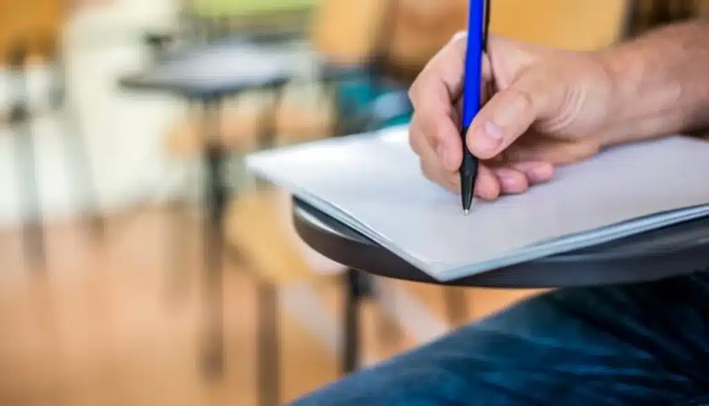 Etapas do Concurso da Prefeitura Municipal Pessoa escrevendo em um papel, simbolizando a preparação e participação nas etapas do concurso público.