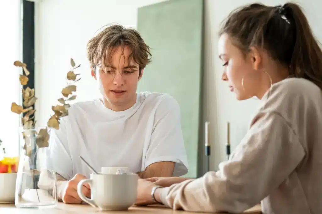 O significado do contato visual na comunicação interpessoal. Homem olhando para baixo enquanto conversa com uma mulher, evitando contato visual.