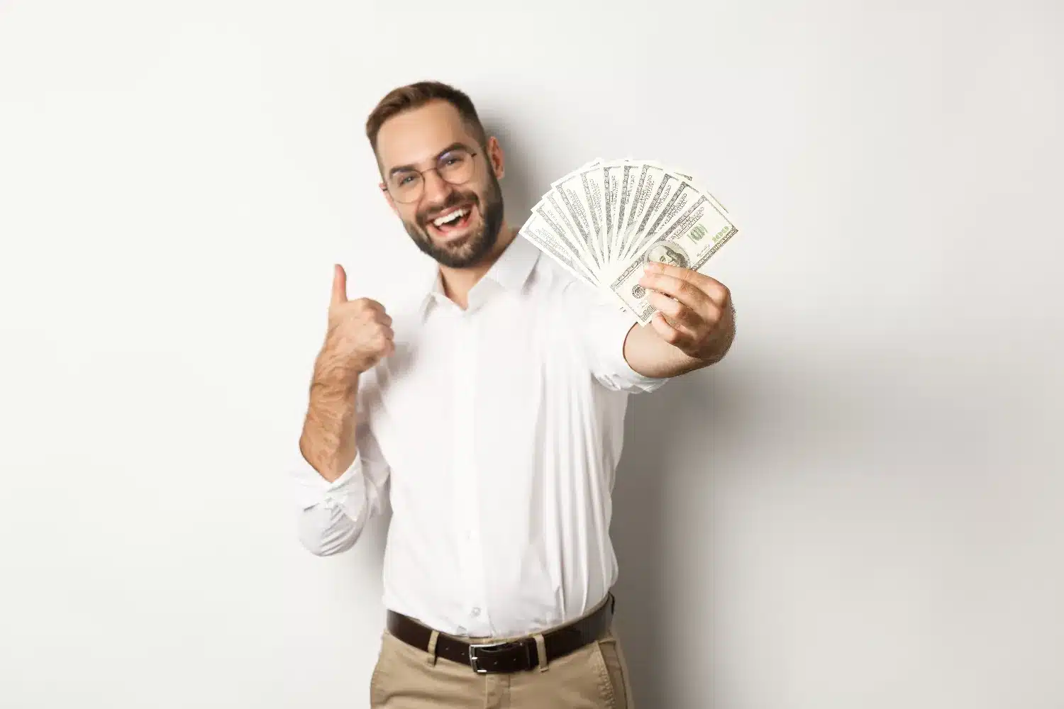 Homem sorrindo e exibindo notas de dinheiro, representando uma profissão que oferece mais de R$ 5 mil sem exigir faculdade.