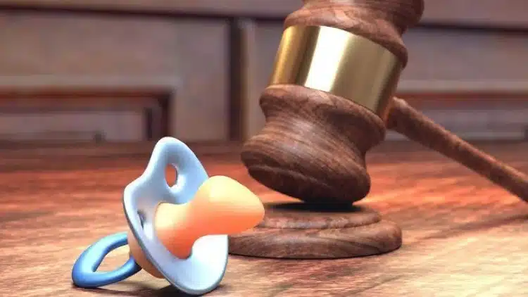 Pensão alimentícia e responsabilidades legais Chupeta e martelo de juiz, representando o processo de solicitação de pensão alimentícia