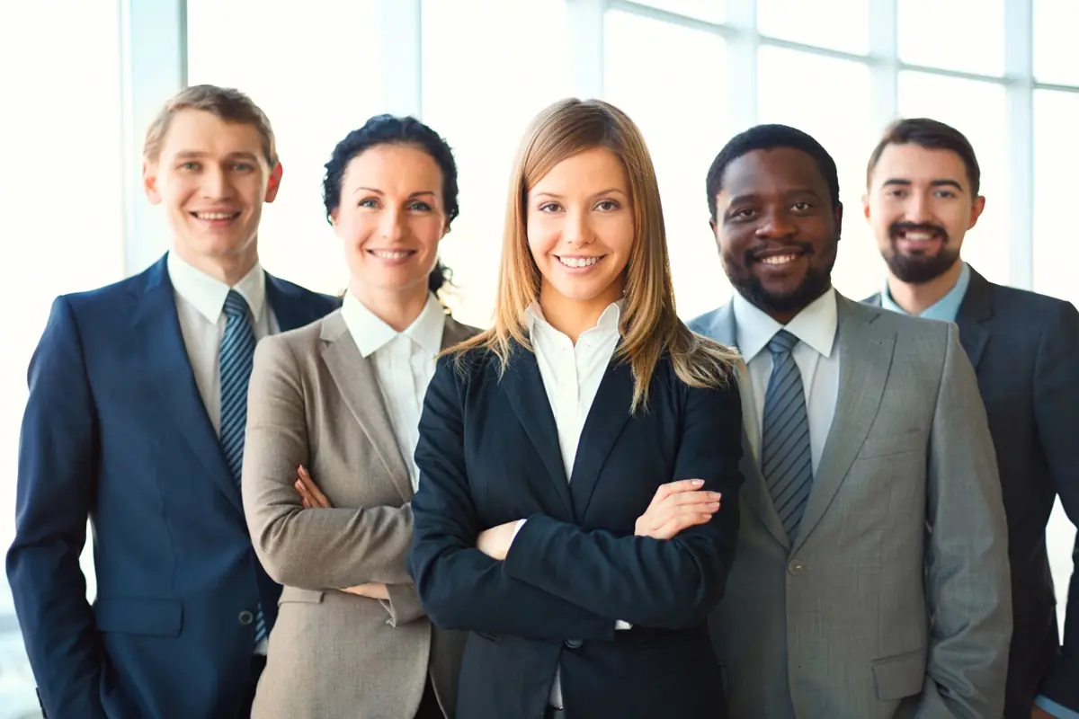 Como funciona o empréstimo consignado para CLT Grupo de profissionais sorrindo em um ambiente corporativo, simbolizando trabalhadores da CLT que podem solicitar o empréstimo consignado.