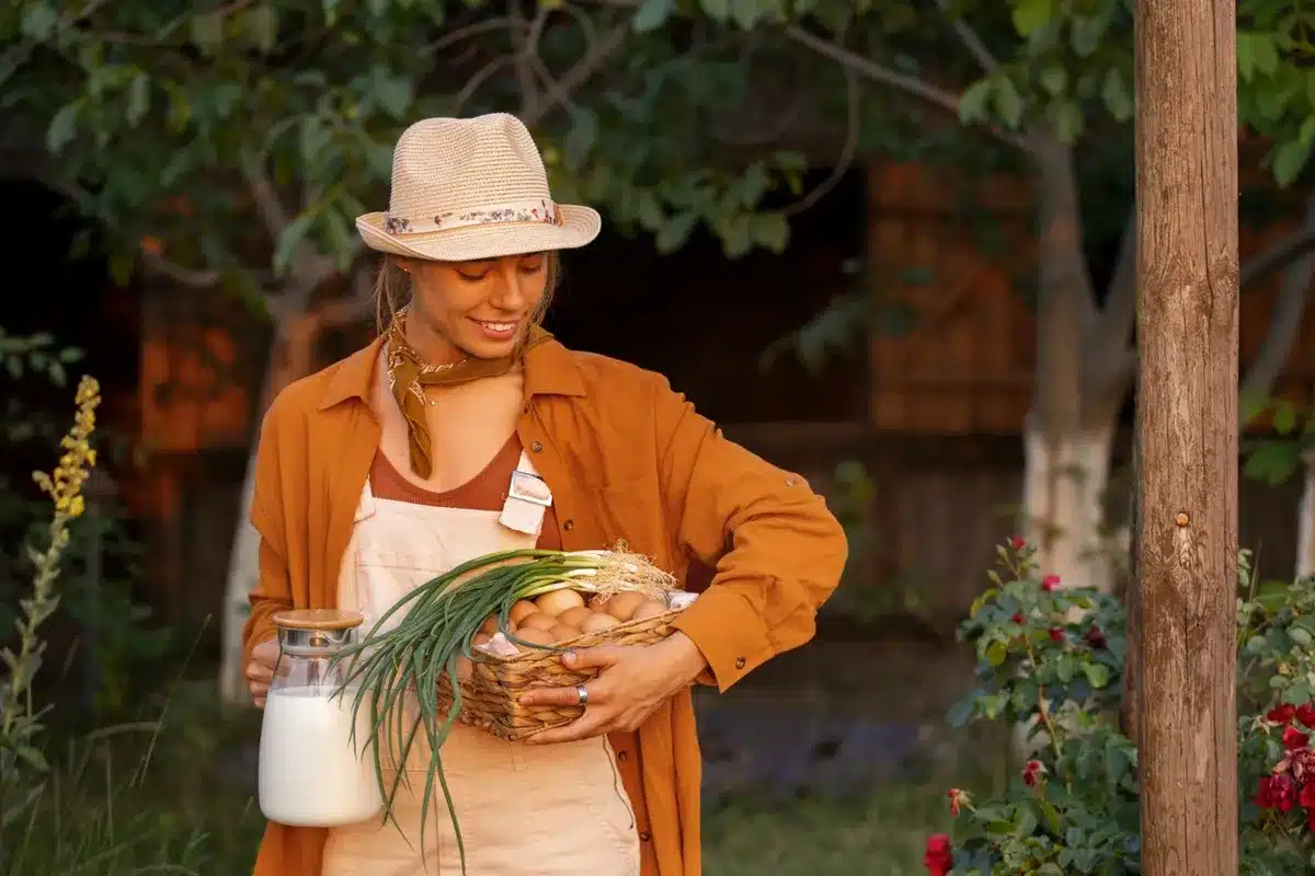 Mulher com chapéu e avental, carregando ovos e cebolas no campo, representando as trabalhadoras rurais que podem se beneficiar dos direitos previdenciários do INSS. Benefícios do INSS para trabalhadoras rurais