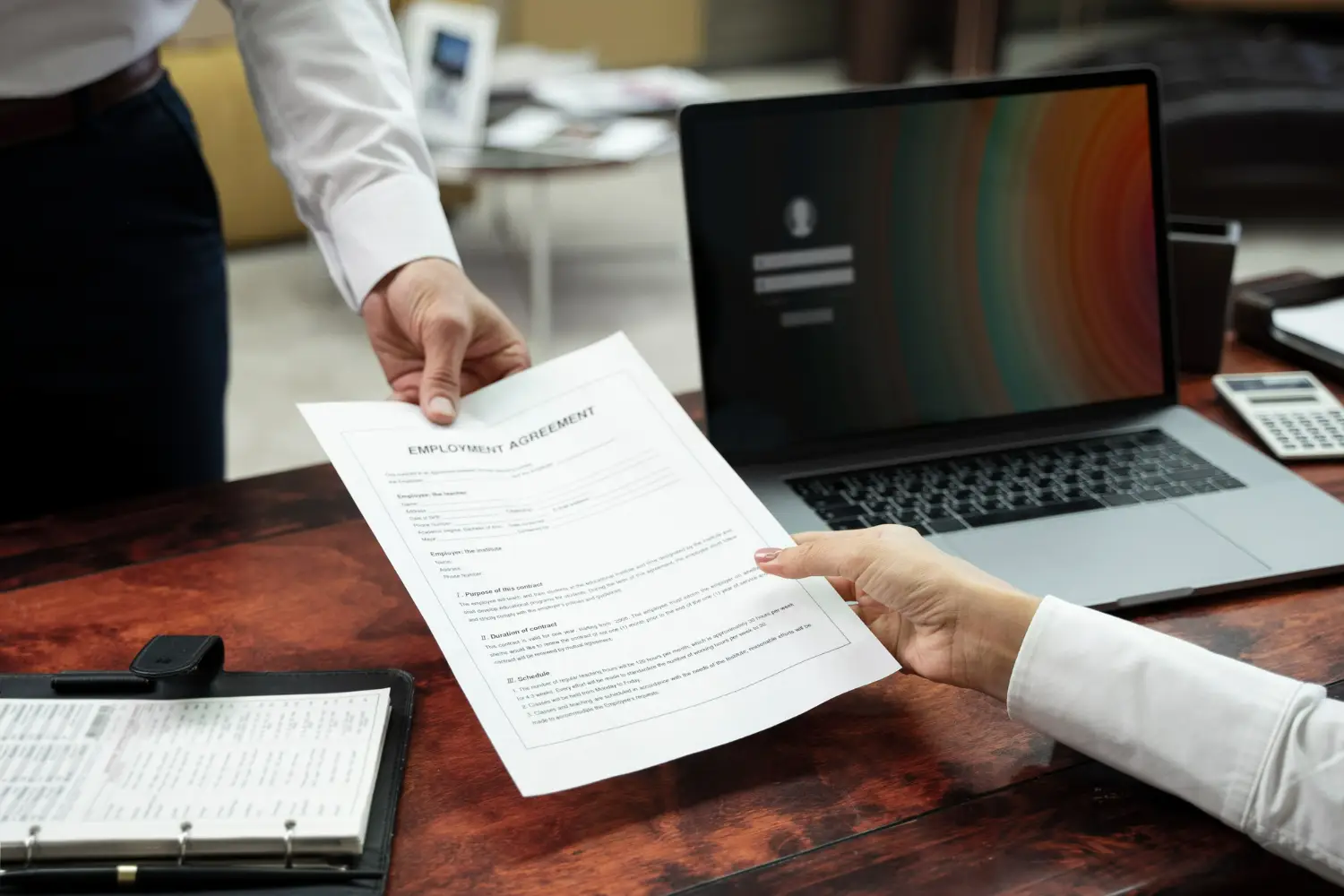 Pessoa entregando contrato de trabalho a outra pessoa, simbolizando uma contratação rápida.