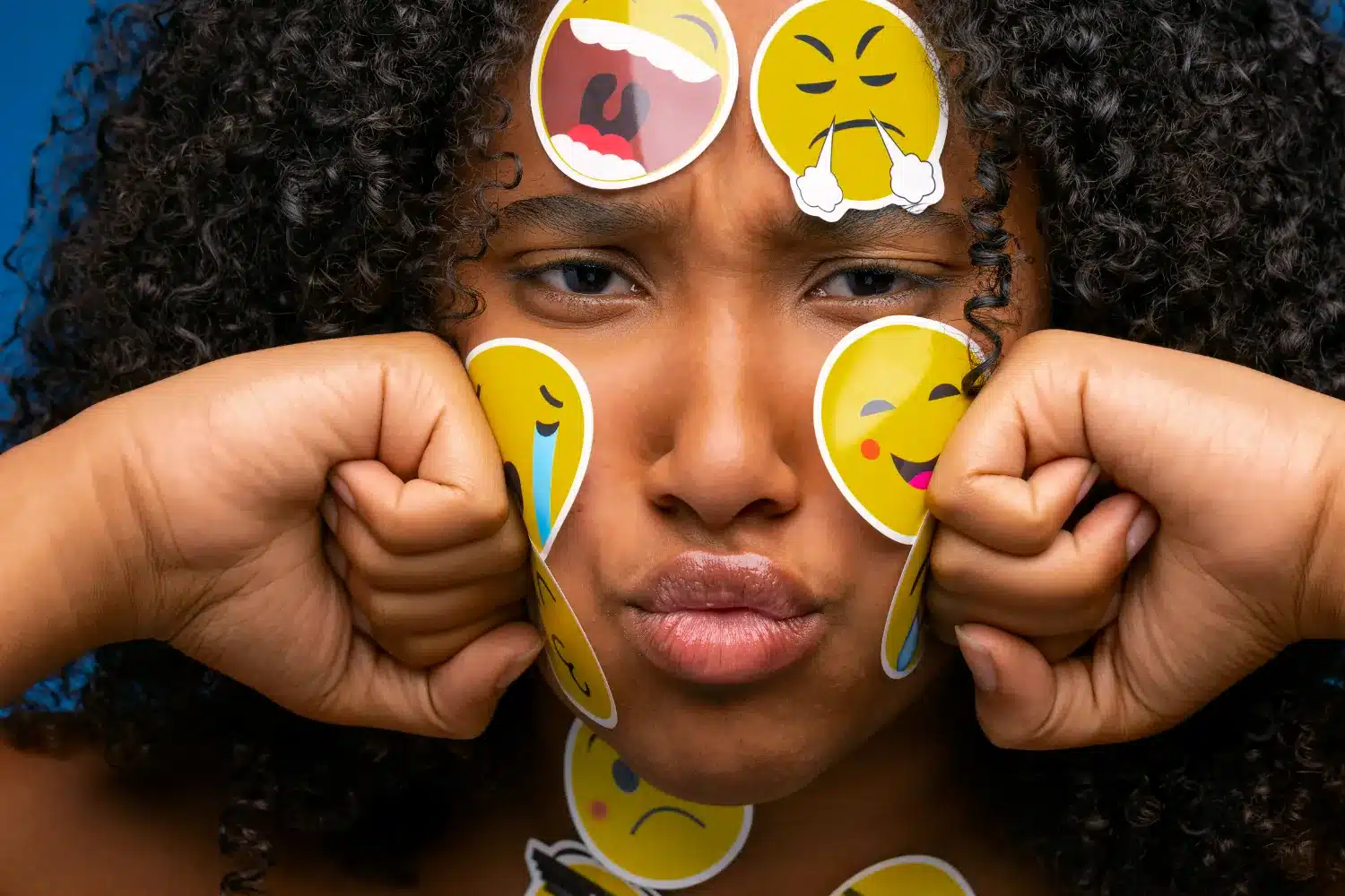 Entenda o transtorno de personalidade borderline e aprenda a identificar seus sinais Mulher com adesivos de emoticons nas expressões faciais, ilustrando as emoções intensas associadas ao transtorno de personalidade borderline.