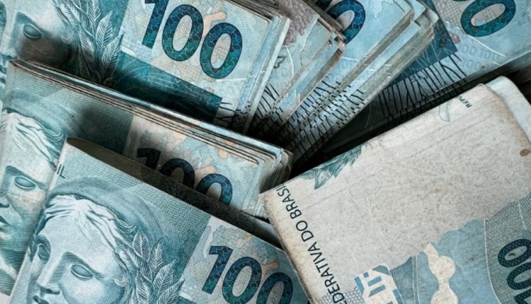 Antecipação do 13º salário para aposentados e pensionistas do INSS Notas de R$100 empilhadas, representando o valor do 13º salário antecipado para aposentados e pensionistas do INSS.