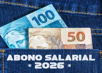 Cédulas de R$ 100 e R$ 50 saindo do bolso de uma calça jeans, representando o pagamento do Abono Salarial 2026