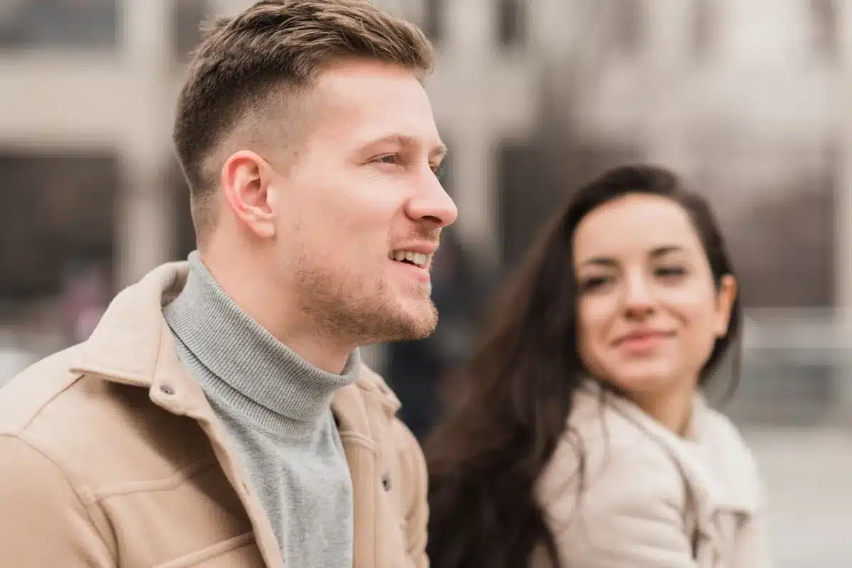 Casal sentado ao ar livre, com uma expressão de atração e admiração um pelo outro