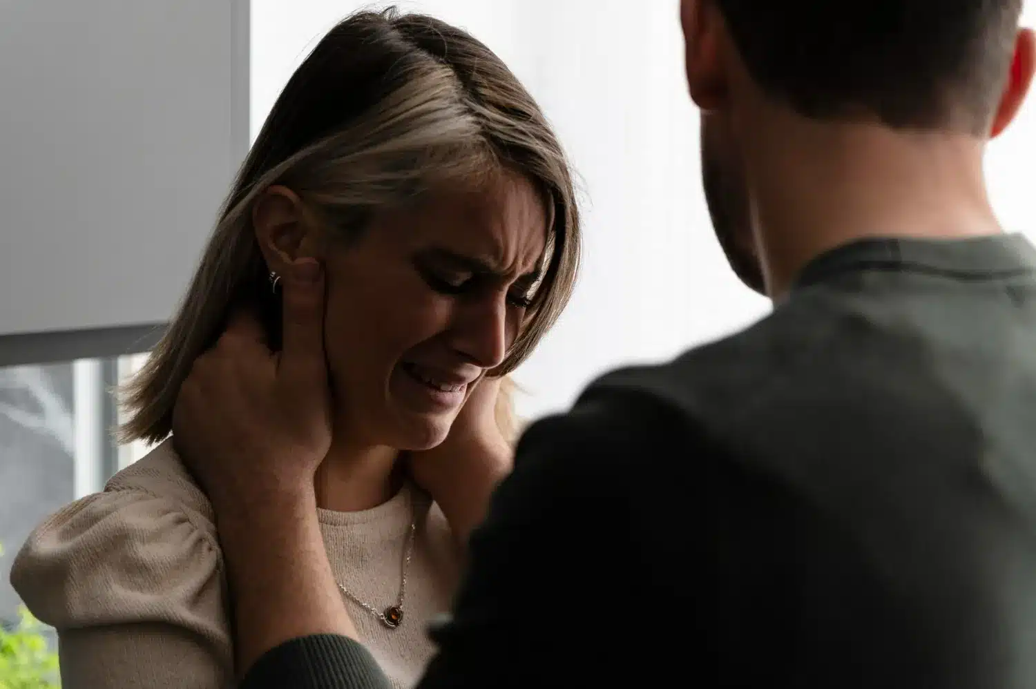 Impacto emocional de um relacionamento abusivo na autoestima Mulher chorando sob intimidação, representando queda na autoestima em relação abusiva.