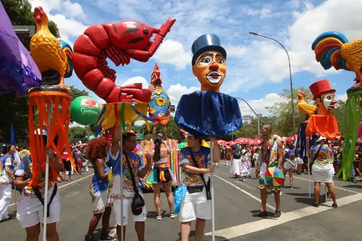 Bloco de Carnaval com grandes bonecos coloridos.