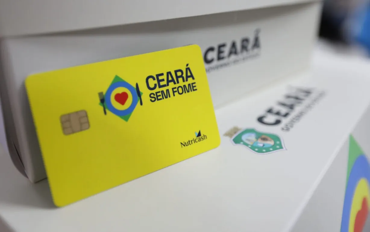 Cartão do programa estadual de combate à fome. Cartão do programa Ceará Sem Fome em destaque sobre caixa com logotipo do governo estadual.