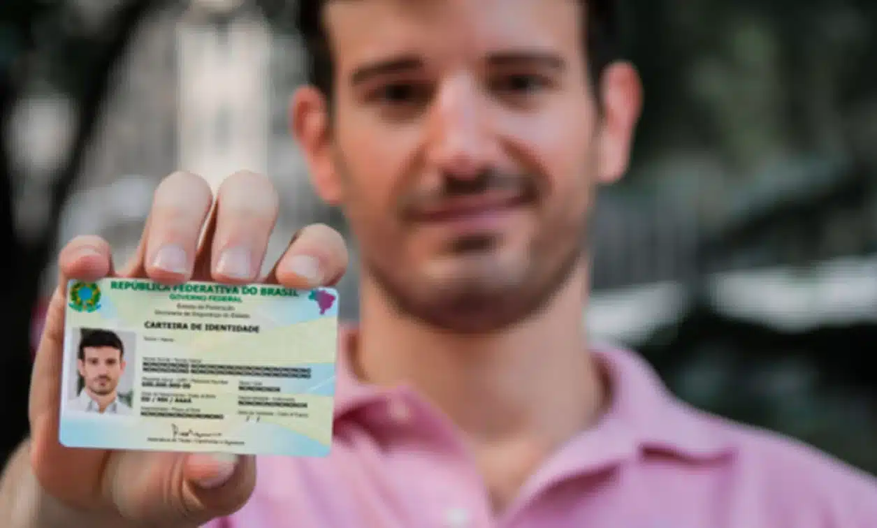 Homem exibindo sua Carteira de Identidade Nacional (CIN) com sorriso, simbolizando a emissão do novo documento.