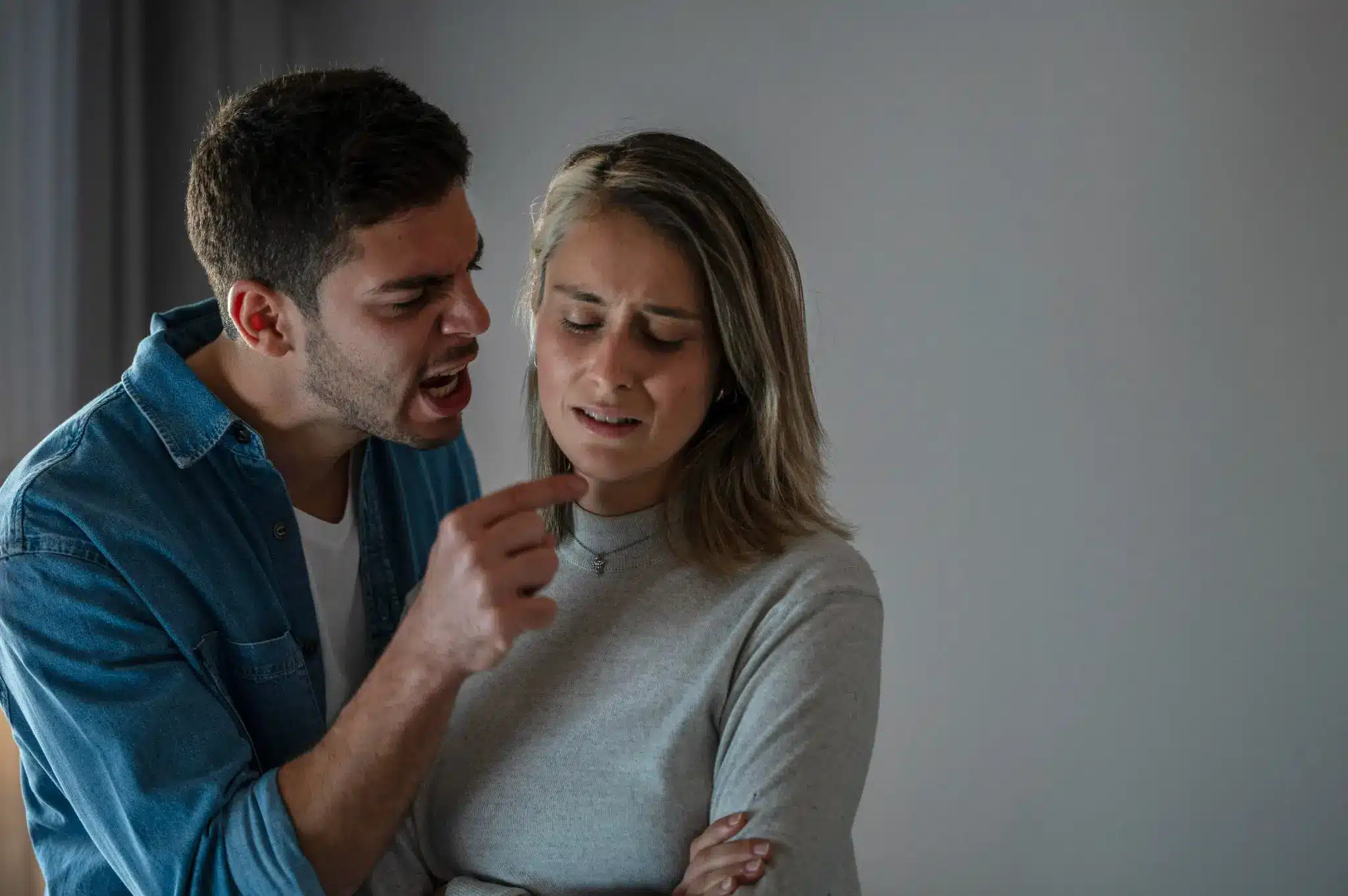 Homem e mulher discutindo em casa, mulher visivelmente desconfortável.