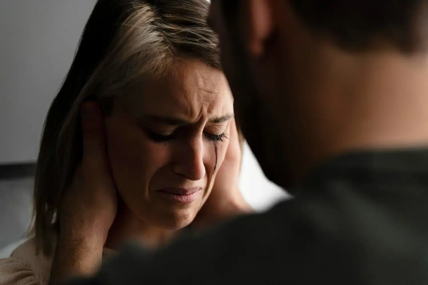 Chantagem emocional: 'Olha o que você me fez fazer! Mulher em sofrimento emocional, com o homem a pressionando, ilustrando uma situação de chantagem emocional.