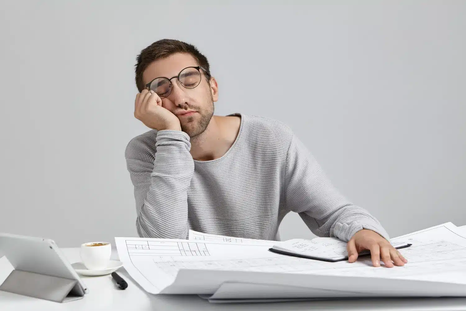 A Procrastinação no Perfeccionismo: Como o Medo de Não Ser Perfeito Impede Ação Homem cansado e desmotivado, refletindo a procrastinação em tarefas.