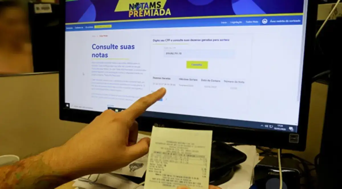 Consulta de sorteios da Nota Premiada MS pela internet. Pessoa consulta sorteios da Nota MS Premiada em site oficial.