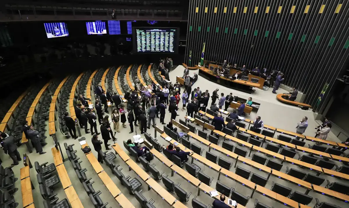 Discussões fervorosas no Congresso sobre as propostas do governo Vista panorâmica do plenário da Câmara dos Deputados, com membros do Congresso em debate e discussões intensas no centro.
